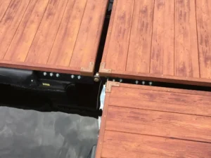 Close-up of AlumaDeck aluminum decking with a wood-look finish, reinforced metal framing, and secure fasteners.