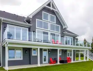 Modern lakeside deck with topless glass railings, offering unobstructed water views and a stylish outdoor seating area.