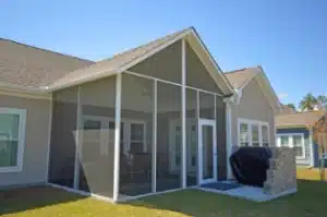 Screen Rooms Model 100 with a gable roof, white frame, and mesh enclosure attached to a modern home.