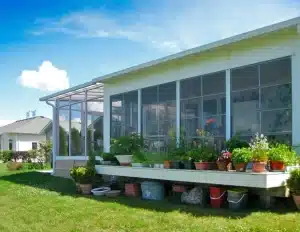 Sunspace Sunrooms Model 100 with large windows and a garden-filled patio.