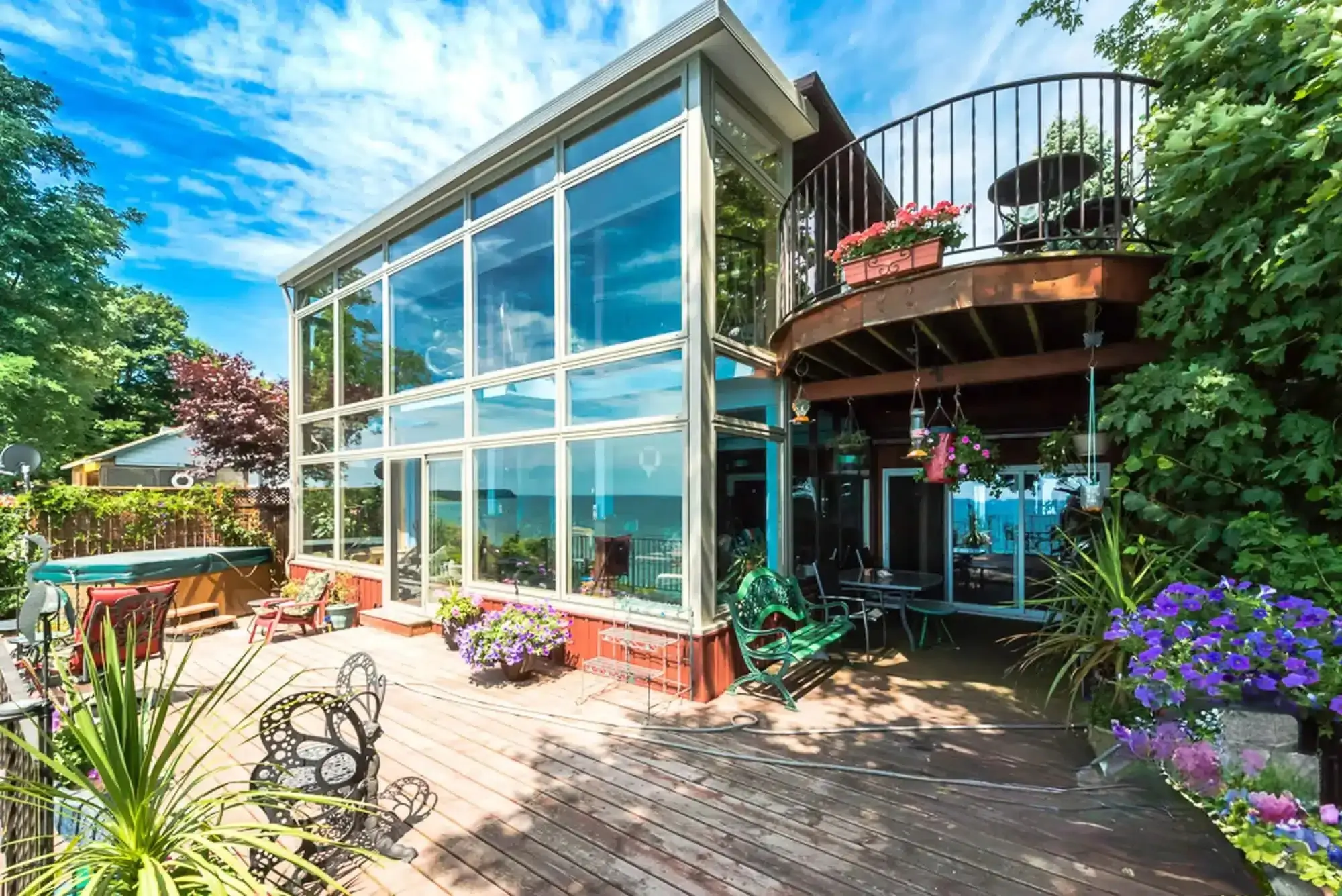 4 Seasons Sunroom Model 400 with floor-to-ceiling glass windows and a wooden deck.