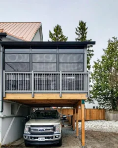Elevated 3-season vinyl sunroom featuring Sunspace WeatherMaster™ Model 200 with horizontal windows, built over a parking area.