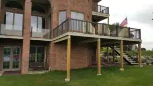 A multi-level brick home featuring a water-shedding decking system, with a dry patio space beneath and a stylish railing design.