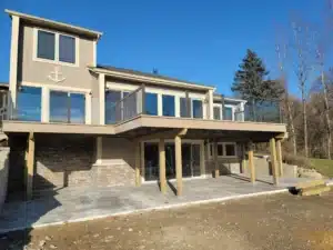 An elevated deck with water-shedding decking, featuring a modern railing system and a dry, protected patio area underneath.