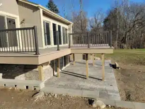 A modern elevated deck with water-shedding decking, featuring a stylish railing system, designed to keep the area below dry and protected.