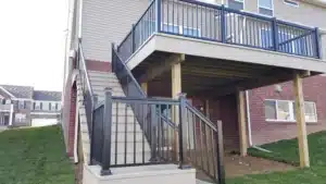 Black aluminum picket railing installed on a raised deck with a staircase, enhancing safety and aesthetics of an outdoor living space
