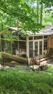 Cozy WeatherMaster™ sunroom Model 200 with large glass windows and a classic sloped roof, blending seamlessly with the natural surroundings for a perfect indoor-outdoor experience