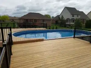 Trex Composite Decking surrounding an above-ground pool with black metal railings, offering a stylish and durable outdoor living space