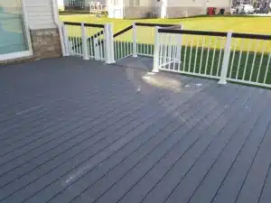 Gray Trex Composite Decking with white and black railing, creating a durable and elegant outdoor space with a ramp entrance