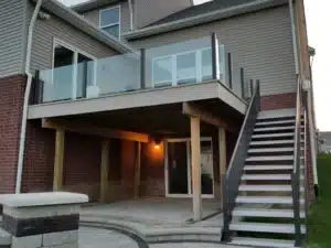 Water Shedding Decking installed on an elevated deck with a modern glass railing, designed to keep the area below dry and functional