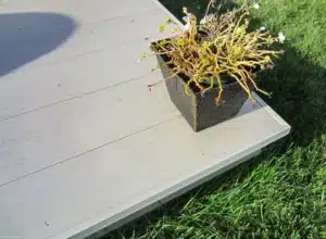 AlumaDeck decking system installed on a spacious outdoor patio with wooden steps and a built-in seating area.